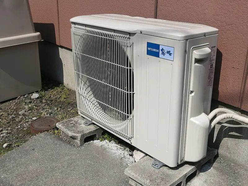 Outdoor air conditioner condenser unit beside a house