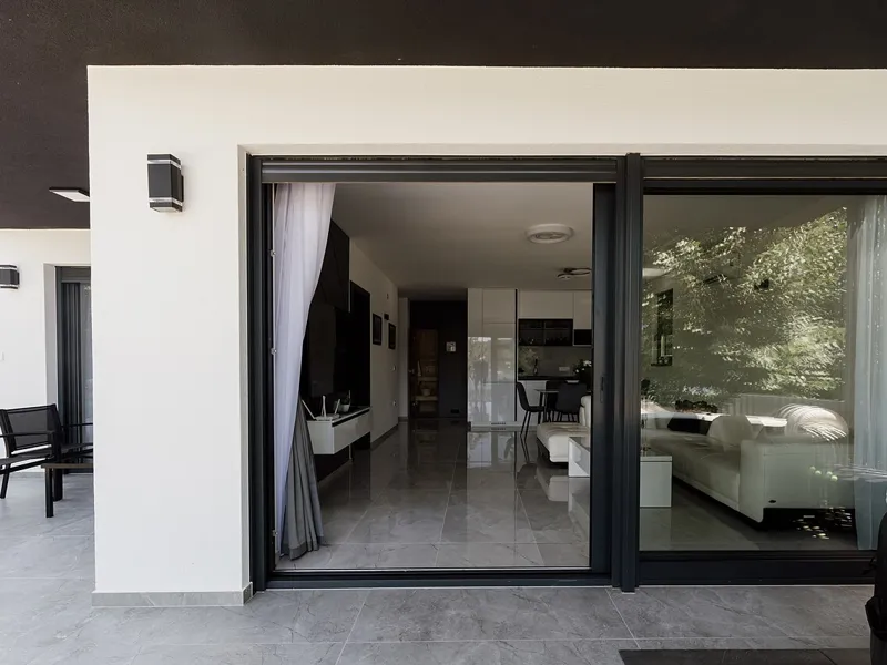 Living room opening onto a patio through sliding glass doors